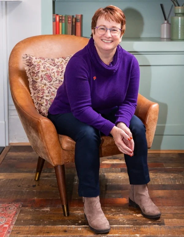 Ashfold Consulting Linda Gent Executive Coaching Linda Gent in portrait sitting in a chair, leaning forward and smiling at the camera